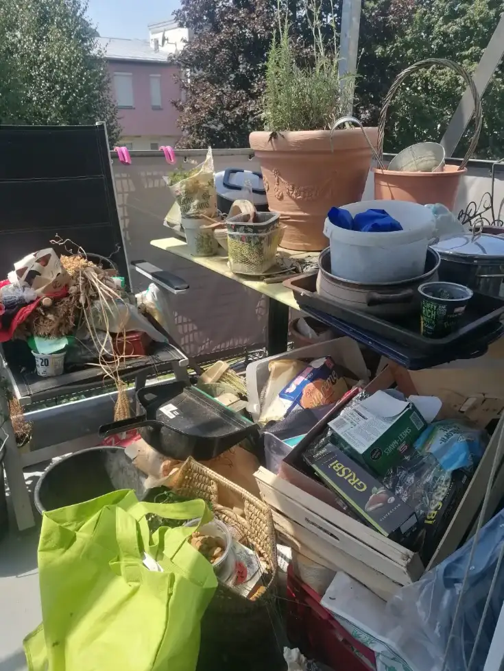 Zugestellter Balkon mit Pflanzen und Altlasten
