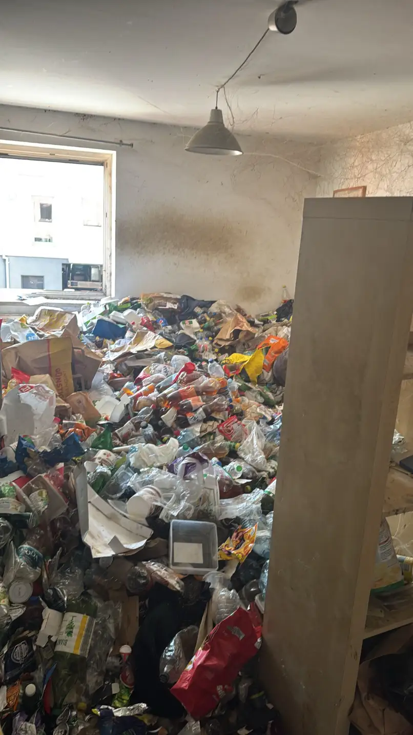 Raum voller Müll und Altlasten vor der Räumung