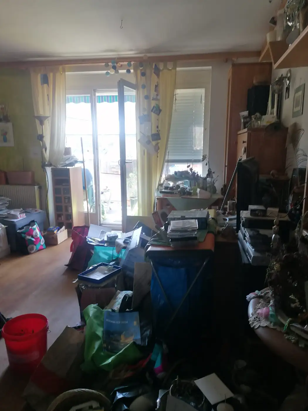 Wohnzimmer mit Kartons, Altpapier und Gerümpel